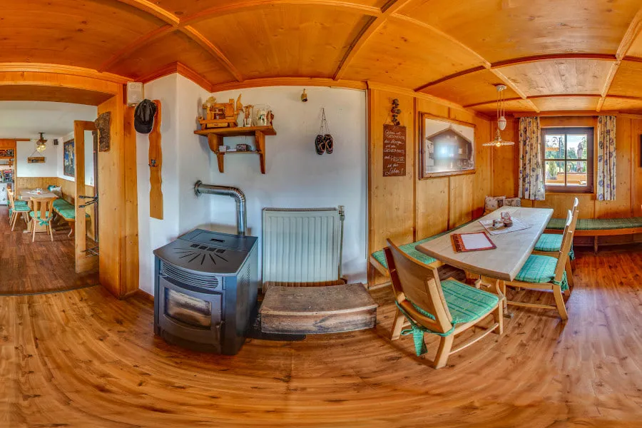 Die Stube der Tennalm mit Kaminofen und Sitzbänken